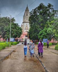 Rear view of people walking on footpath