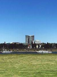 Buildings in city against clear blue sky