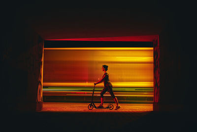 Side view of man cycling at night