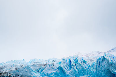 Scenic view of snowcapped mountains against clear sky