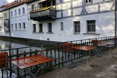 Empty chairs and tables against buildings in city