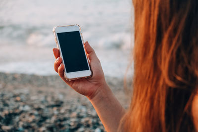 Midsection of woman using mobile phone outdoors