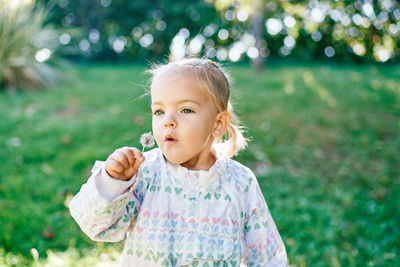 Portrait of cute girl standing against plants