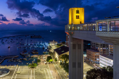 Famous lacerda elevator illuminated at night with city and boats in background in salvador, bahia