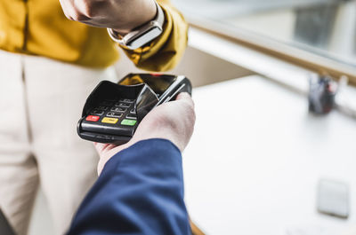 Businesswoman paying with smart watch on card reader machine