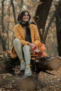 Portrait of young woman sitting in forest