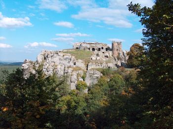 Old ruin building on mountain in forest against sky