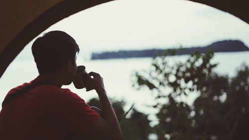 Rear view of man photographing through camera