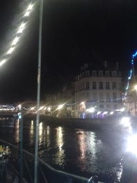 Road passing through illuminated city at night