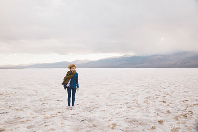 Young woman standing at death valley national park against cloudy sky