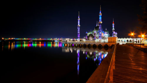 Reflection of illuminated mosque in calm river