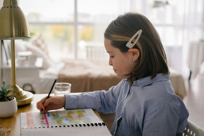 Side view of woman working at table