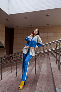 Full length portrait of woman standing on mobile phone