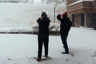 Rear view of couple standing in snow