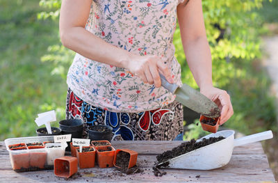 Midsection of woman gardening on table