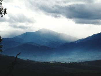 Scenic view of mountains against cloudy sky