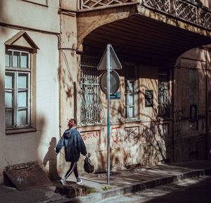 Rear view of man sitting outside building