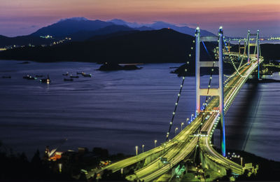 View of suspension bridge over river at night