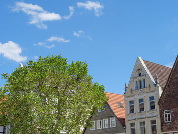 Low angle view of trees and building against sky