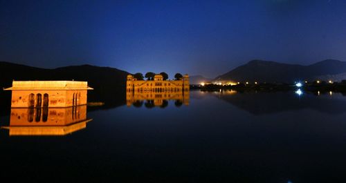 Illuminated buildings against clear sky at night