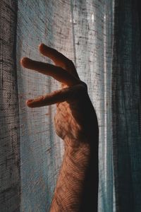Close-up of human hand against wall