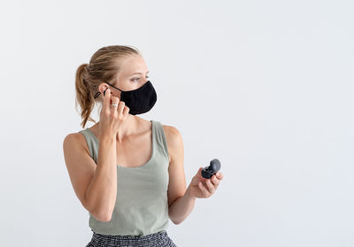 Young woman using mobile phone against white background