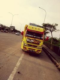 Cars on road against sky in city