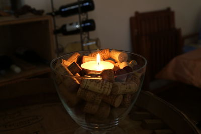 Candle lit place in bowl of glass on top of wine cork bottle cap