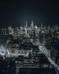 Illuminated cityscape against sky at night