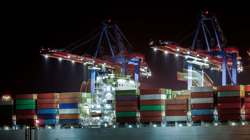 Illuminated commercial dock against sky at night