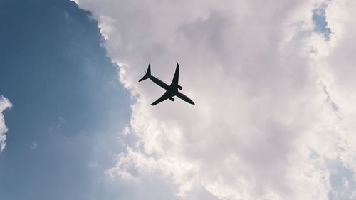 Low angle view of airplane flying against sky