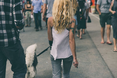 Rear view of people walking on street in city