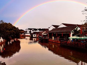 Rainbow over buildings and houses against sky