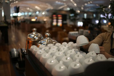 Midsection of person on table in illuminated restaurant