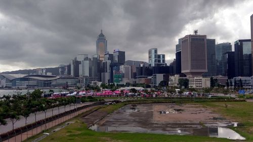 View of skyscrapers in city against cloudy sky
