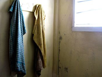 Close-up of clothes hanging on window at home