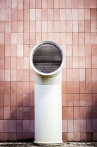 Electric lamp on tiled floor against wall