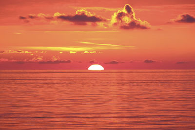 Scenic view of sea against romantic sky at sunset