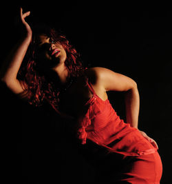 Young woman standing against black background