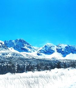 Scenic view of snowcapped mountains against clear blue sky