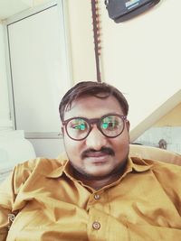 Portrait of young man wearing eyeglasses at home