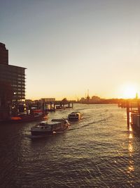 Boats in sea against sky during sunset