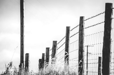 Fence on field against clear sky