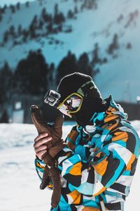 Man photographing with umbrella standing on snow