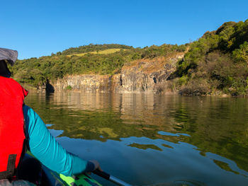 Reflection of man in lake against blue sky