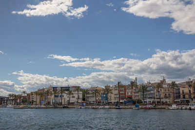 Buildings by sea against sky in town