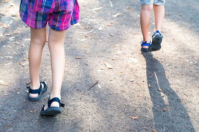 Low section of women walking on street