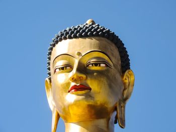 Low angle view of statue against blue sky