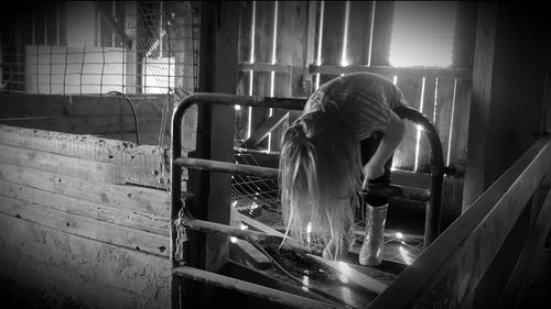 Full length of girl playing on railing in abandoned room