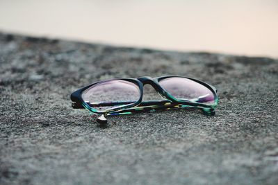 Close-up of sunglasses on sand